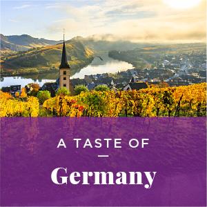 A vineyard overlooking a valley with German architecture. Text: Taste of Germany